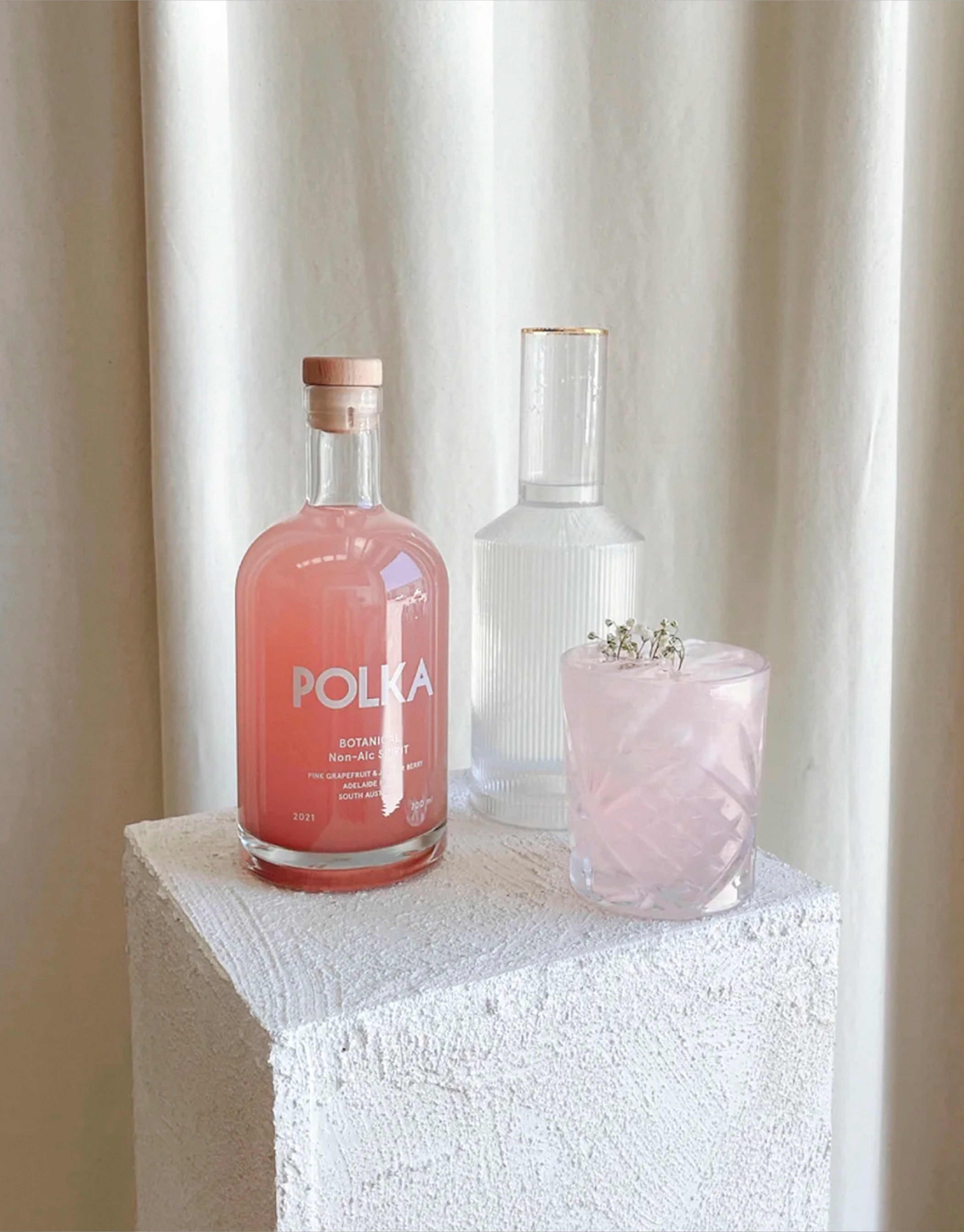 Mocktail with non-alcoholic botanical spirit next to the bottle