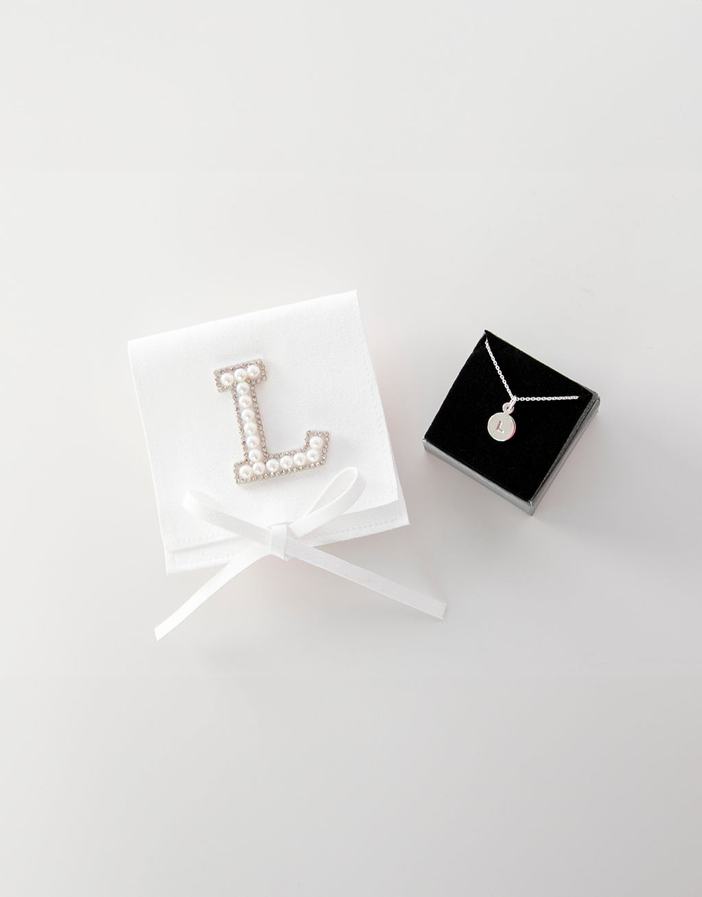 23Dreams Handmade Sueded White Pouch - Personalised with Letter "L" in white pearl and rhinestone patch next to letter necklace "L" in silver